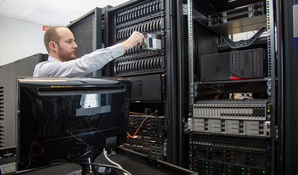 Técnico de IT num data center a inserir um disco num servidor
